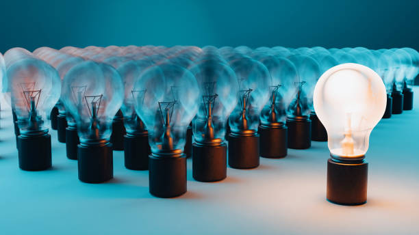A glowing light bulb stands out among unlit bulbs.