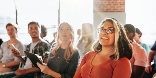 Smiling woman in glasses at a group meeting.